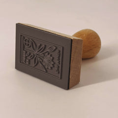 Ex-libris stamp of a flowering plant with a target